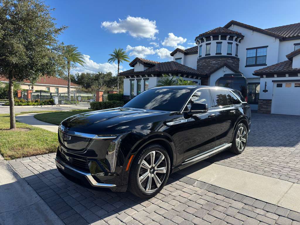 Sleek black SUV parked on a sunny residential driveway.