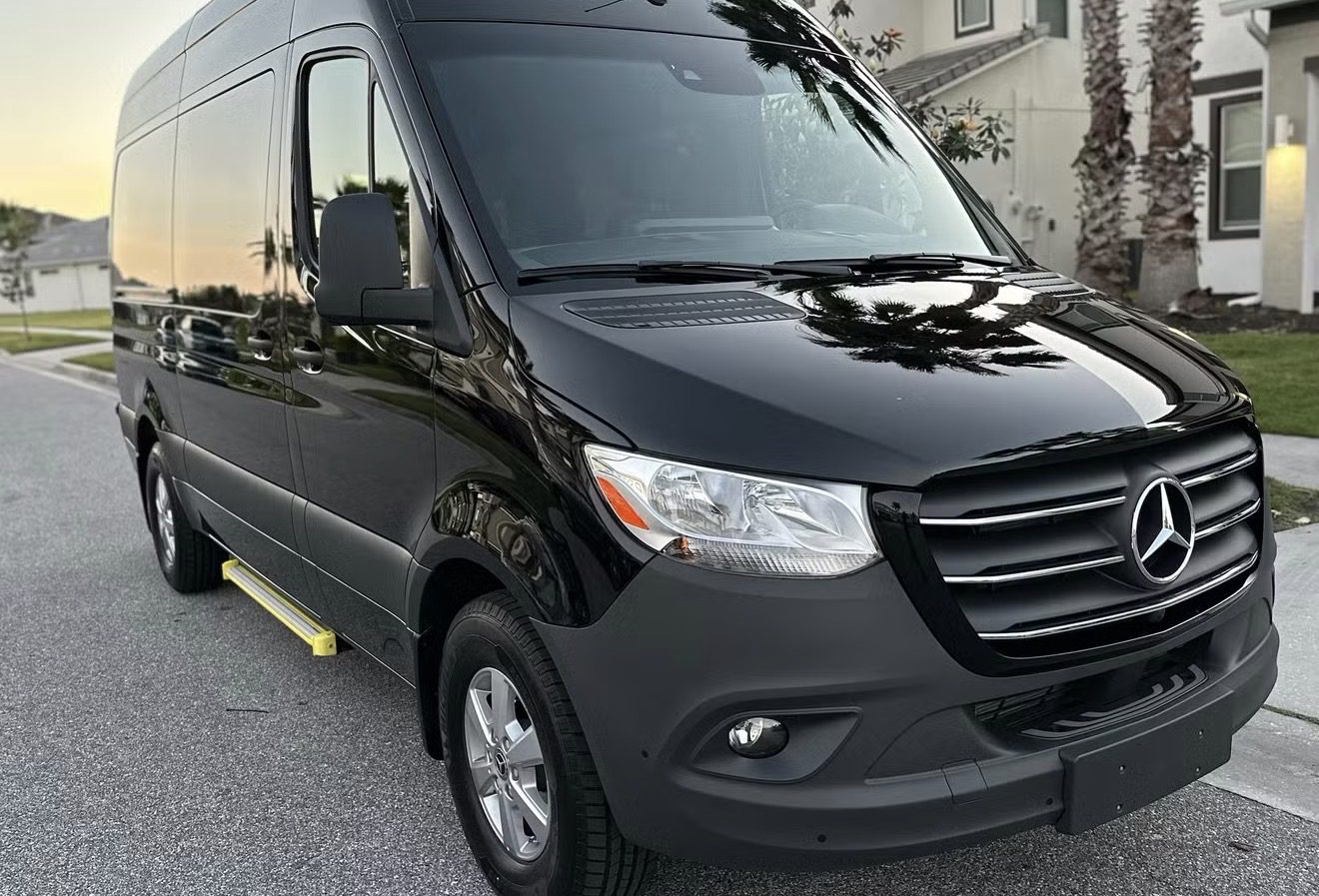Black cargo van parked outdoors under daylight.