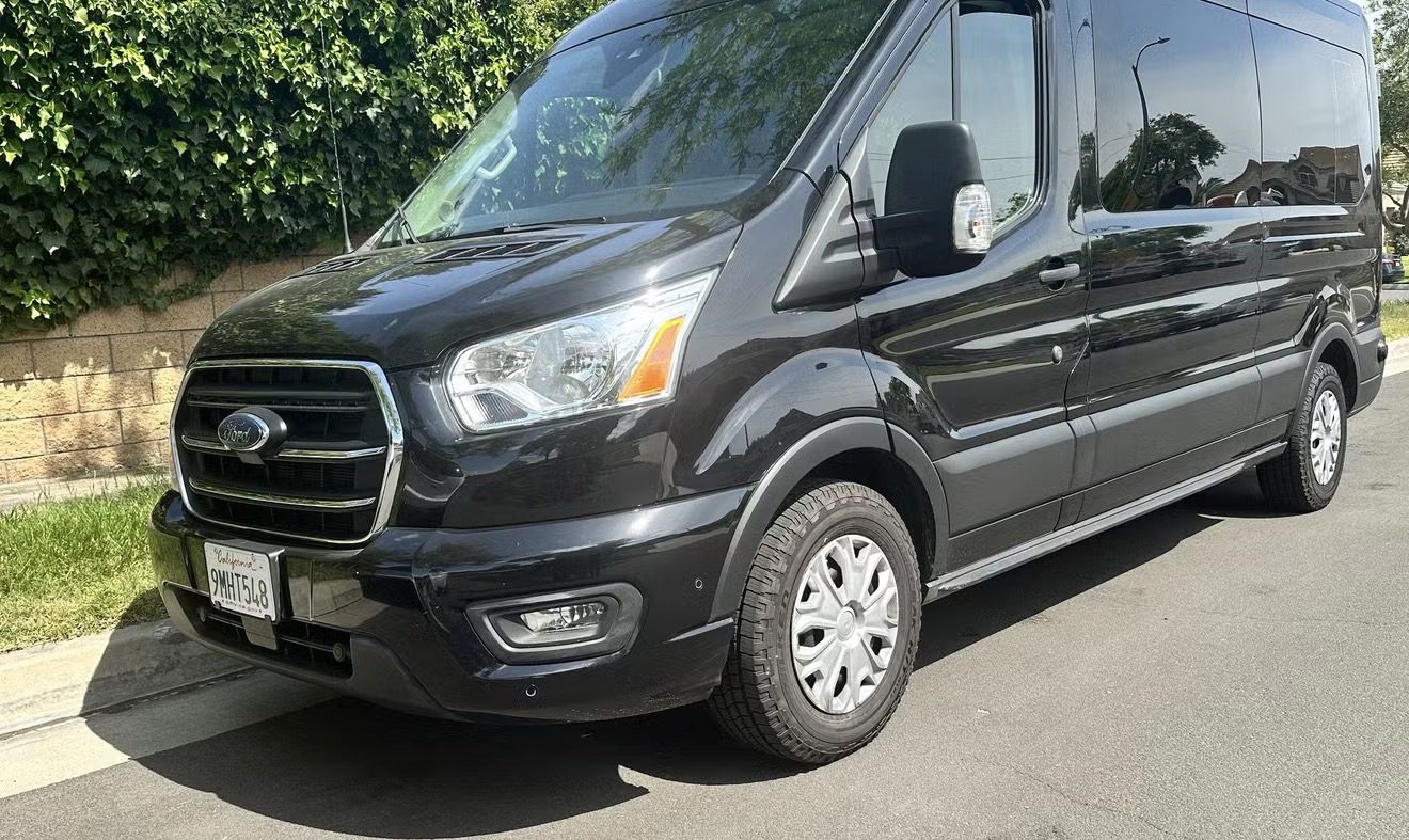 Black cargo van parked on the street in daylight.