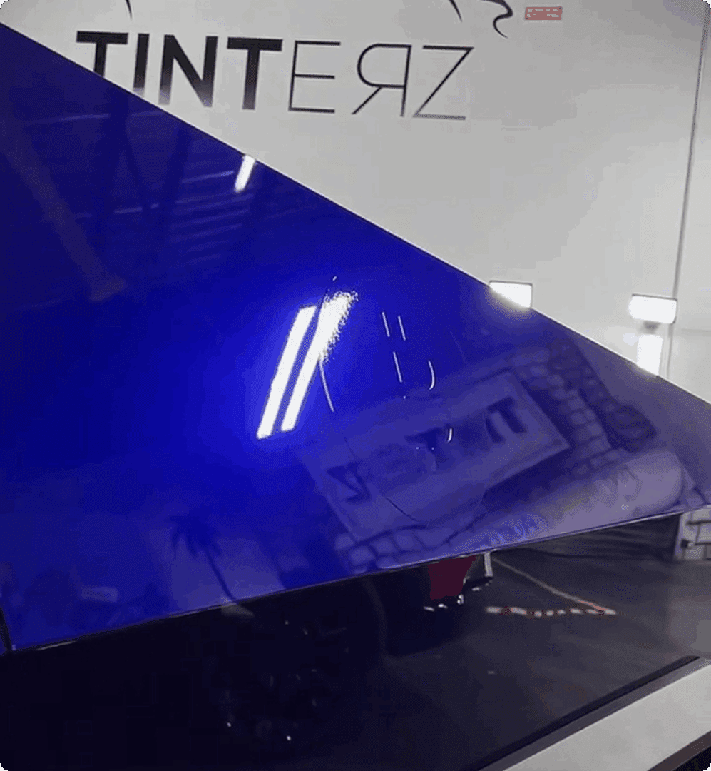 Glossy blue car surface indoors